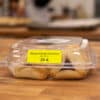 A clamshell labeled "Allergen Friendly Assortment (NF, GF, V) 37-A" with a dozen hamantaschen inside.