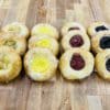 A dozen assorted fruit Kolache. From left to right, apple, lemon, cherry, and blueberry.