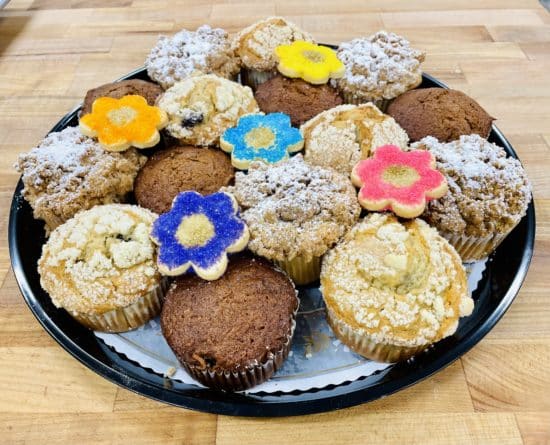 Large muffin platter with 15 muffins, decorated with 5 sunflower sugar cookies. 5 each of morning glory, lemon blueberry, and cinnamon crumb muffins.