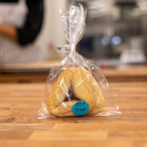 Traditional favor bag, labeled with "39-F Trad". Two traditional hamantaschen can be seen in the cello bag.