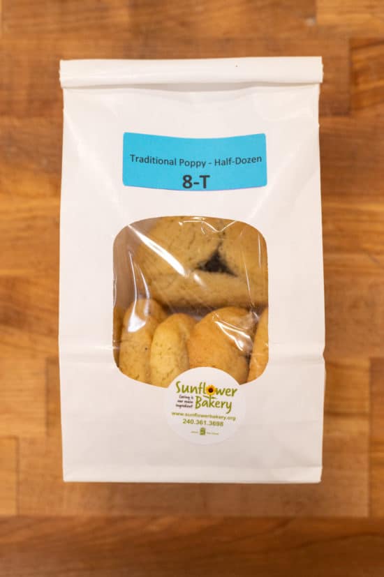 Window bag labeled "Traditional Poppy - Half-Dozen 8-T" with traditional poppy hamantaschen visible through the window.