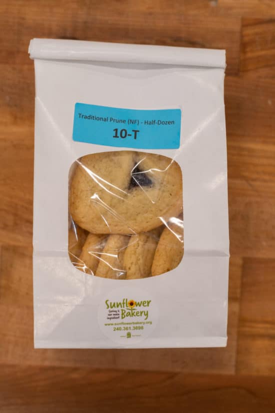 Window bag labeled "Traditional Prune (NF) - Half-Dozen 10-T" with traditional prune hamantaschen visible through the window.