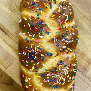 Braided challah with sprinkles decorating the golden top.