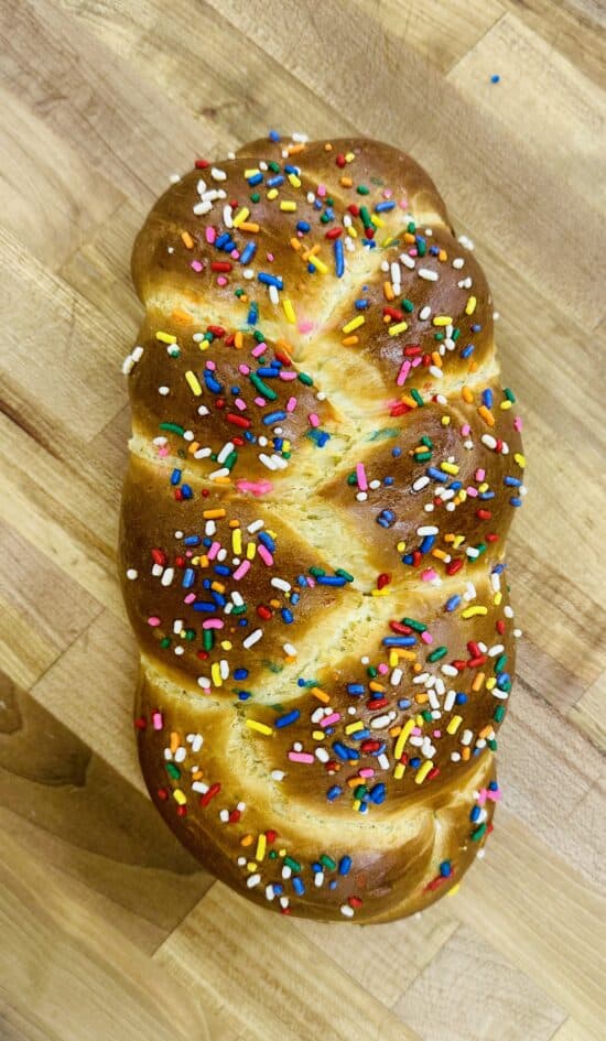 Braided challah with sprinkles decorating the golden top.