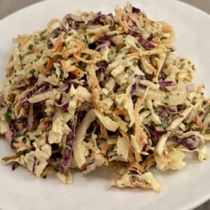 Coleslaw piled on a white plate.