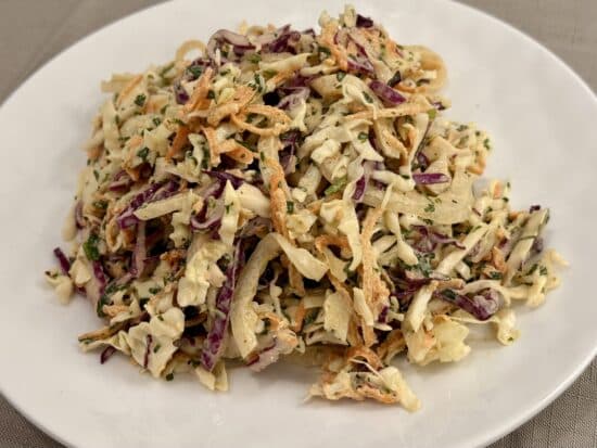 Coleslaw piled on a white plate.
