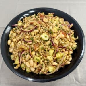 Black bowl filled with farro and bean salad.