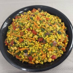Black bowl filled with moroccan couscous salad.