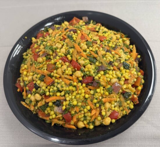 Black bowl filled with moroccan couscous salad.