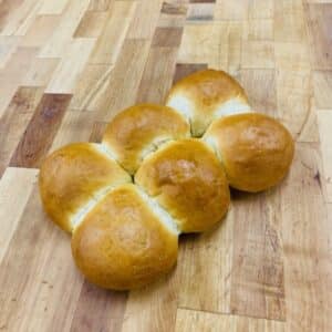 6 Pull-apart challah rolls on a wooden countertop