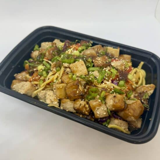 Spicy tofu stir-fry in a to-go container.