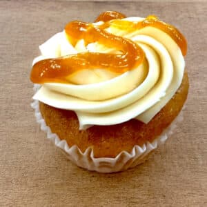 A single Apricot Dream Cupcake on a wooden surface
