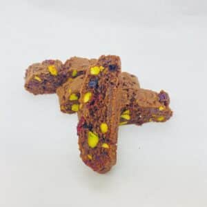 Slices of chocolate pistachio mandel bread on a white background.